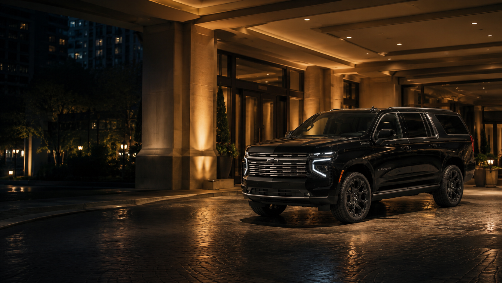 Black luxury SUV at night with a city backdrop
